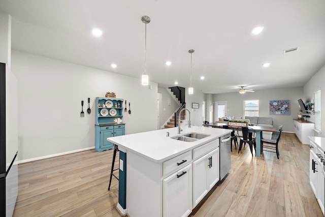 2218 Royal Ann Way, Tomball, TX 77375 - kitchen featuring stainless steel dishwasher, ceiling fan, light wood-style floors, white cabinets, and an island with sink