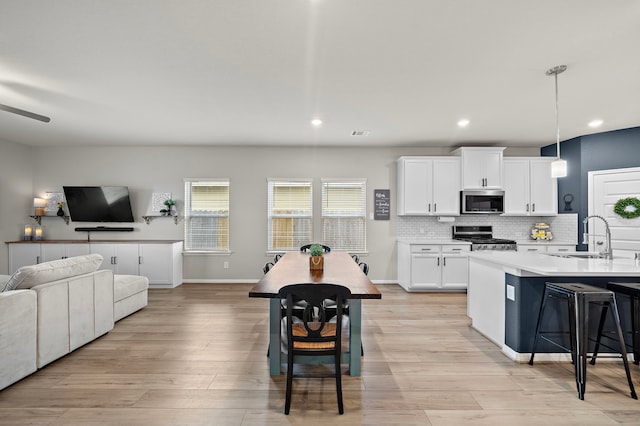 2218 Royal Ann Way, Tomball, TX 77375 - kitchen with appliances with stainless steel finishes, open floor plan, a breakfast bar, light wood-type flooring, and recessed lighting
