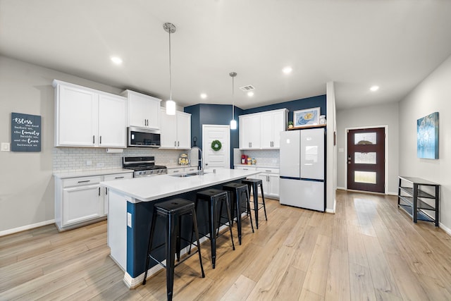 2218 Royal Ann Way, Tomball, TX 77375 - kitchen featuring stainless steel appliances, a kitchen breakfast bar, backsplash, white cabinets, and recessed lighting