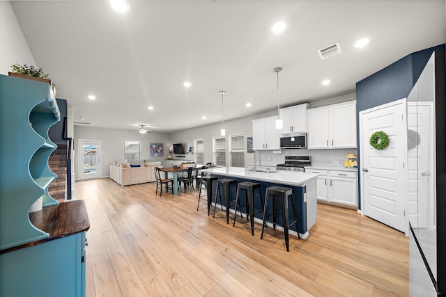 2218 Royal Ann Way, Tomball, TX 77375 - kitchen with appliances with stainless steel finishes, open floor plan, a kitchen breakfast bar, white cabinets, and a center island with sink