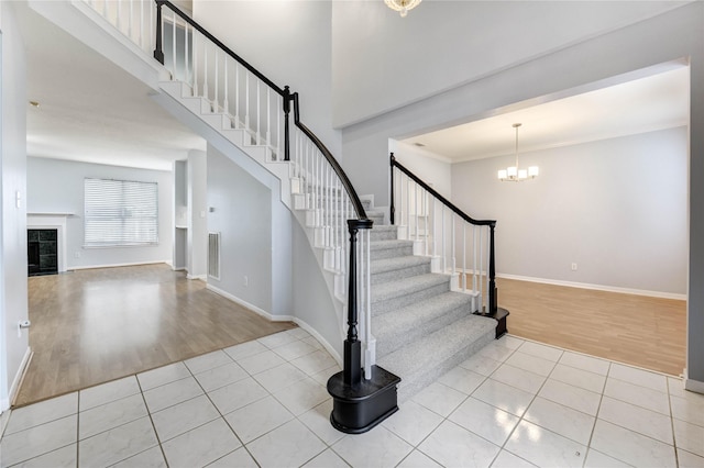 16023 Cutten Rd, Houston, TX 77070 - foyer with wood finished floors, a chandelier, stairs, a tiled fireplace, and ornamental molding
