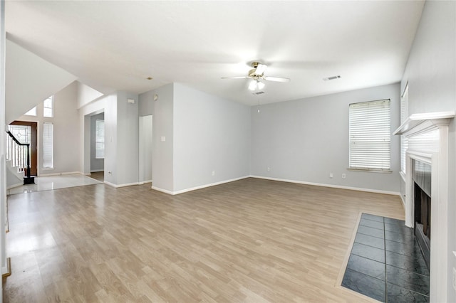 16023 Cutten Rd, Houston, TX 77070 - unfurnished living room with ceiling fan, a fireplace, stairway, and light wood finished floors