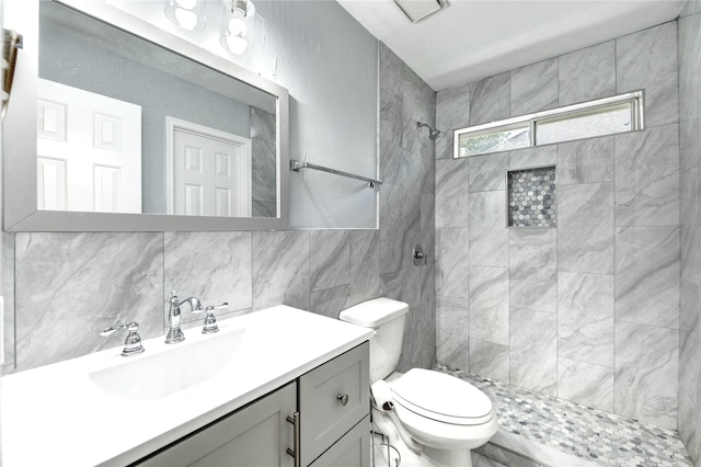 16023 Cutten Rd, Houston, TX 77070 - bathroom with vanity, tiled shower, tile walls, and tasteful backsplash