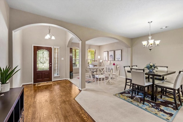 4472 Gerona St, League City, TX 77573 - foyer entrance with arched walkways, a chandelier, and wood finished floors