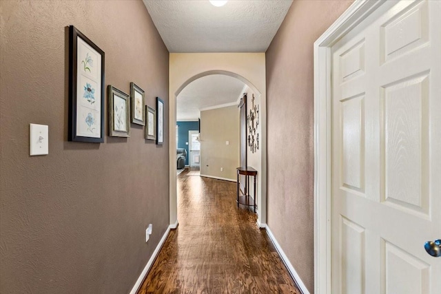 4472 Gerona St, League City, TX 77573 - hall featuring arched walkways, dark wood-style floors, and a textured ceiling