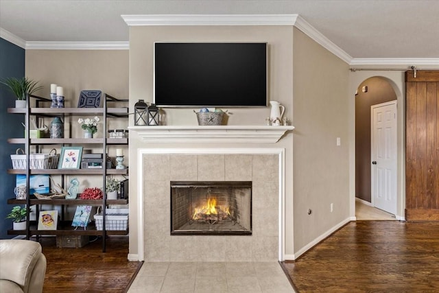 4472 Gerona St, League City, TX 77573 - living area featuring arched walkways, ornamental molding, wood finished floors, and a tiled fireplace