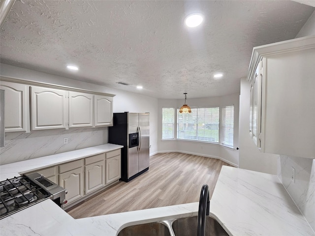 14519 Cypress Valley Dr, Cypress, TX 77429 - kitchen with appliances with stainless steel finishes, light wood-style flooring, recessed lighting, decorative light fixtures, and a textured ceiling