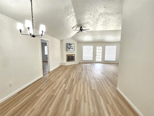 14519 Cypress Valley Dr, Cypress, TX 77429 - unfurnished living room featuring a chandelier, a ceiling fan, lofted ceiling, light wood-type flooring, and a textured ceiling