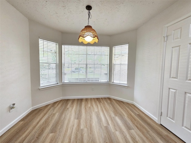 14519 Cypress Valley Dr, Cypress, TX 77429 - unfurnished dining area featuring light wood-style flooring, healthy amount of natural light, and a textured ceiling