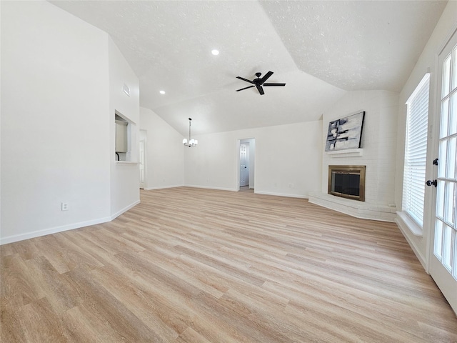 14519 Cypress Valley Dr, Cypress, TX 77429 - unfurnished living room with vaulted ceiling, a brick fireplace, a chandelier, ceiling fan, and light wood finished floors