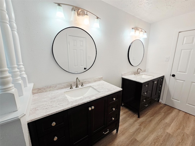 14519 Cypress Valley Dr, Cypress, TX 77429 - bathroom with two vanities, wood finished floors, and a textured ceiling