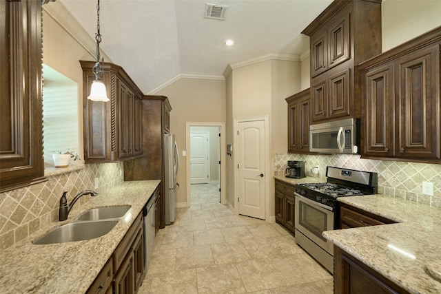 11917 Walden Rd, Montgomery, TX 77356 - kitchen featuring stainless steel appliances, lofted ceiling, dark brown cabinetry, light stone counters, and crown molding