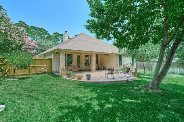 11917 Walden Rd, Montgomery, TX 77356 - rear view of property featuring a chimney, a fenced backyard, a patio area, roof with shingles, and brick siding