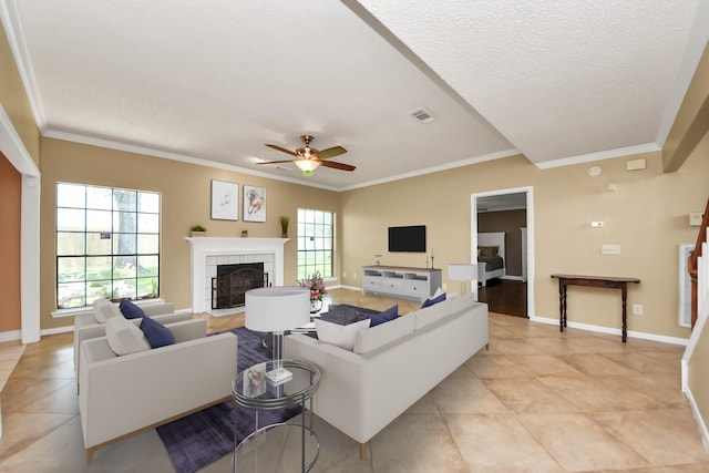 3107 Dulaney Rd, Houston, TX 77084 - living room featuring light tile patterned flooring, a fireplace, crown molding, a ceiling fan, and a textured ceiling