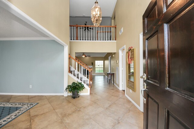3107 Dulaney Rd, Houston, TX 77084 - foyer entrance featuring light tile patterned flooring, a chandelier, stairs, crown molding, and a high ceiling