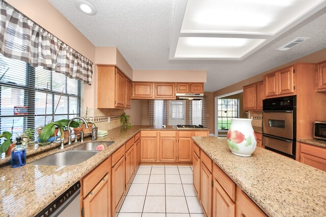 3107 Dulaney Rd, Houston, TX 77084 - kitchen featuring appliances with stainless steel finishes, a warming drawer, light tile patterned floors, light stone countertops, and under cabinet range hood