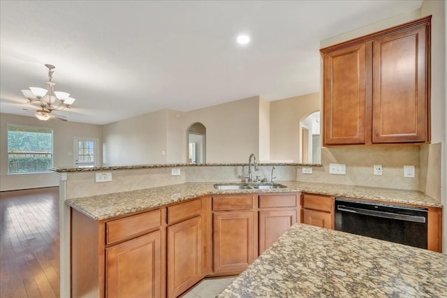 4473 Gran Canary Dr, League City, TX 77573 - kitchen with black dishwasher, arched walkways, a peninsula, a chandelier, and light stone countertops
