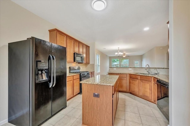 4473 Gran Canary Dr, League City, TX 77573 - kitchen with black appliances, a chandelier, light stone countertops, light tile patterned floors, and a center island