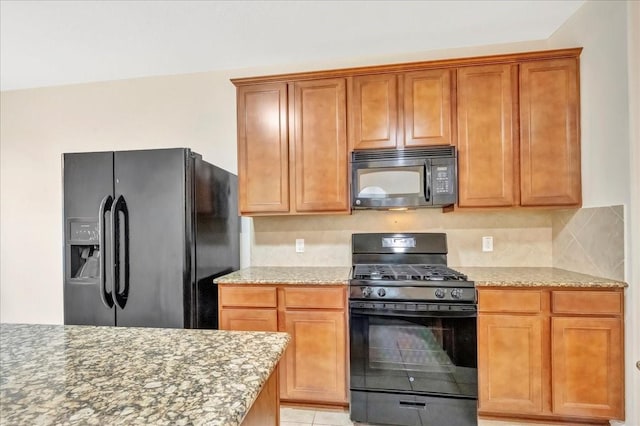 4473 Gran Canary Dr, League City, TX 77573 - kitchen featuring black appliances, light stone countertops, tasteful backsplash, and brown cabinets