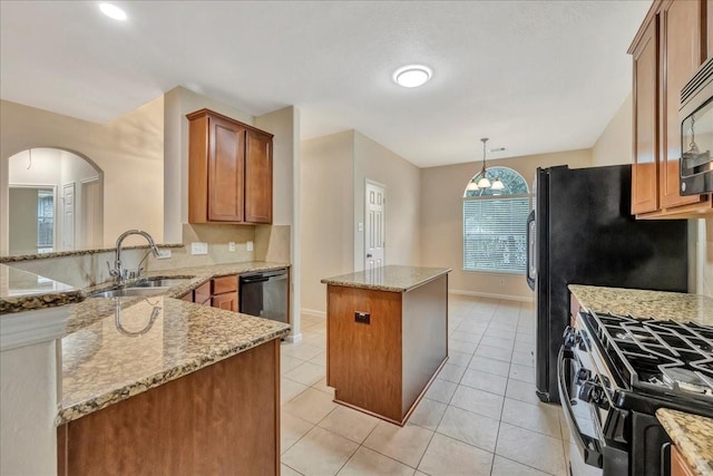4473 Gran Canary Dr, League City, TX 77573 - kitchen with a center island, arched walkways, brown cabinetry, and light stone counters