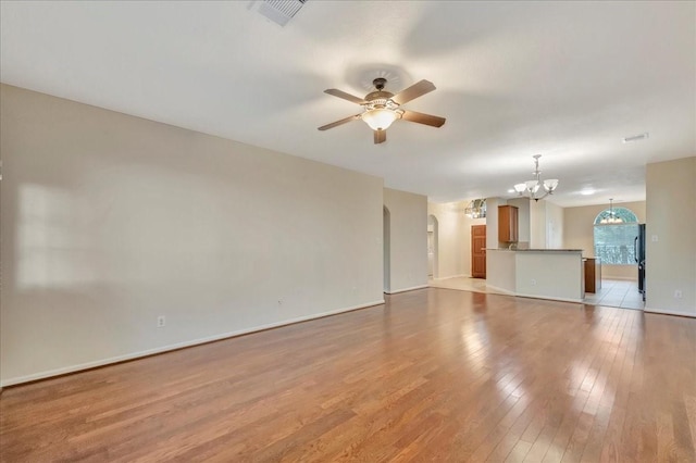 4473 Gran Canary Dr, League City, TX 77573 - unfurnished living room with a chandelier, a ceiling fan, hardwood / wood-style floors, and arched walkways