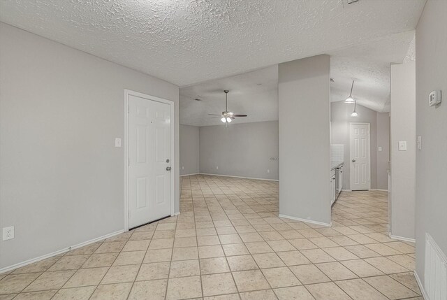 22307 Silver Morning Cir, Katy, TX 77450 - spare room with ceiling fan, a textured ceiling, light tile patterned floors, and vaulted ceiling