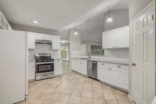 22307 Silver Morning Cir, Katy, TX 77450 - kitchen with appliances with stainless steel finishes, under cabinet range hood, tasteful backsplash, white cabinetry, and a textured ceiling
