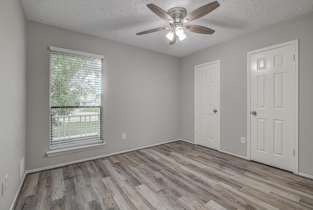 22307 Silver Morning Cir, Katy, TX 77450 - unfurnished bedroom featuring wood finished floors, a textured ceiling, and a ceiling fan