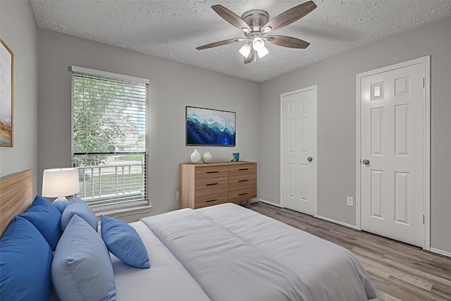22307 Silver Morning Cir, Katy, TX 77450 - bedroom with wood finished floors, a textured ceiling, and a ceiling fan