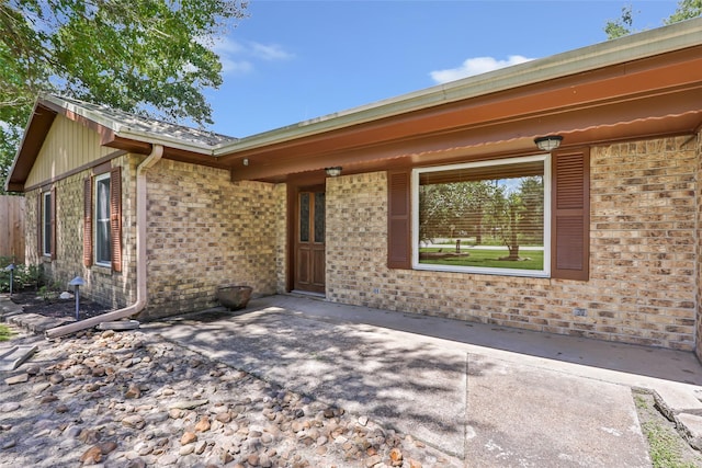14590 N Tram Rd, Splendora, TX 77372 - view of exterior entry featuring brick siding and a patio area