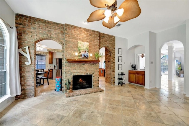 14523 Hillside Hickory Ct, Houston, TX 77062 - unfurnished living room with a ceiling fan, healthy amount of natural light, a fireplace, arched walkways, and brick wall