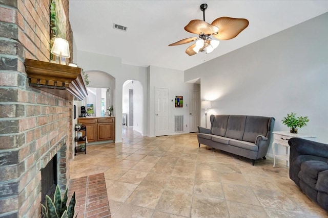 14523 Hillside Hickory Ct, Houston, TX 77062 - living area featuring arched walkways, a ceiling fan, stone tile flooring, and a brick fireplace
