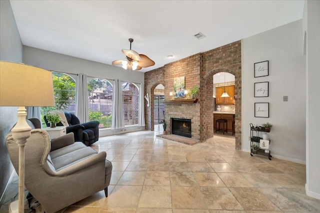 14523 Hillside Hickory Ct, Houston, TX 77062 - living room featuring ceiling fan, a brick fireplace, stone tile floors, arched walkways, and brick wall