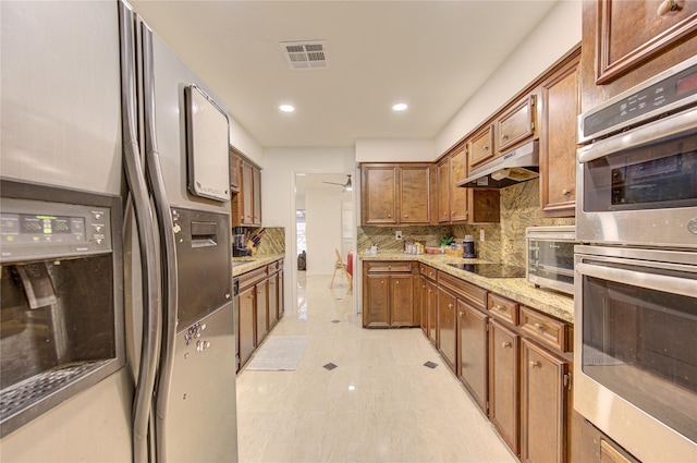 14143 Lost Meadow Ln, Houston, TX 77079 - kitchen featuring fridge with ice dispenser, stainless steel double oven, under cabinet range hood, brown cabinets, and backsplash