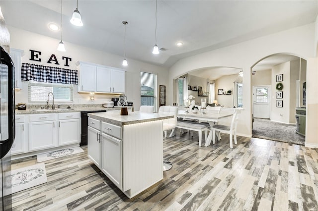 20518 Rimini River Way, Katy, TX 77449 - kitchen featuring black dishwasher, light wood-style flooring, arched walkways, decorative light fixtures, and recessed lighting