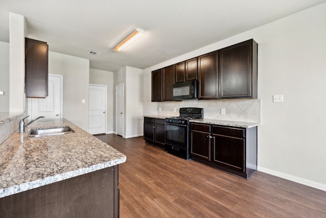 3319 Atascocita Vale Dr, Humble, TX 77396 - kitchen with black appliances, dark wood-type flooring, backsplash, dark brown cabinetry, and light stone counters