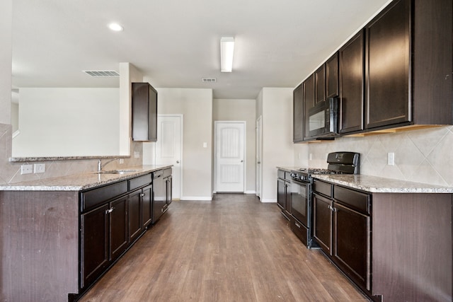3319 Atascocita Vale Dr, Humble, TX 77396 - kitchen with black appliances, dark brown cabinets, light stone counters, and backsplash