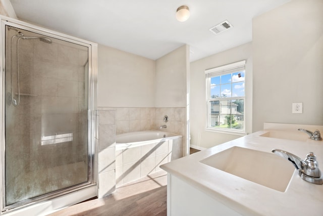 3319 Atascocita Vale Dr, Humble, TX 77396 - bathroom with double vanity, a bath, a stall shower, and wood finished floors
