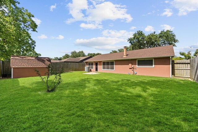 1370 Stevenage Ln, Channelview, TX 77530 - back of property featuring a fenced backyard, a storage shed, roof with shingles, and stucco siding