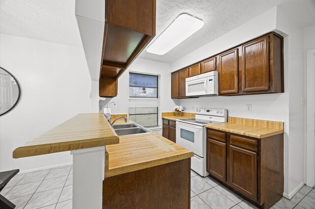 1370 Stevenage Ln, Channelview, TX 77530 - kitchen with white appliances, butcher block countertops, light tile patterned floors, a peninsula, and a textured ceiling