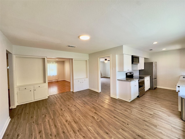 4310 Gallagher Dr, Houston, TX 77045 - kitchen featuring appliances with stainless steel finishes, wood finished floors, white cabinets, and ceiling fan