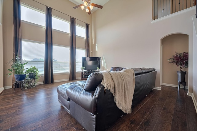 19547 Stetson Heights Ln, Richmond, TX 77407 - living room with arched walkways, a ceiling fan, dark wood finished floors, and a high ceiling