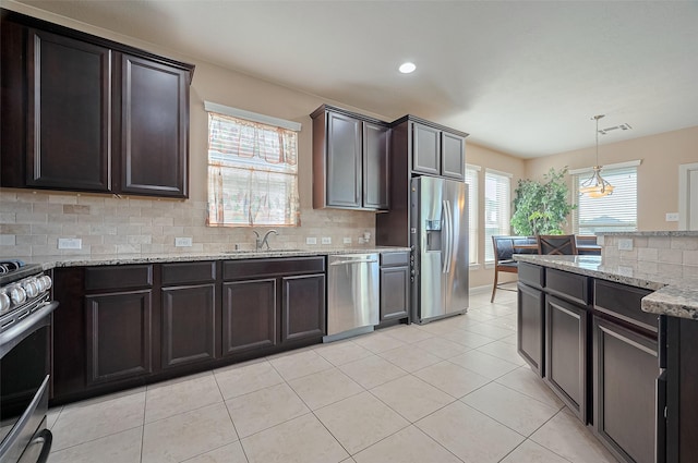 19547 Stetson Heights Ln, Richmond, TX 77407 - kitchen featuring appliances with stainless steel finishes, decorative backsplash, recessed lighting, light stone countertops, and light tile patterned floors
