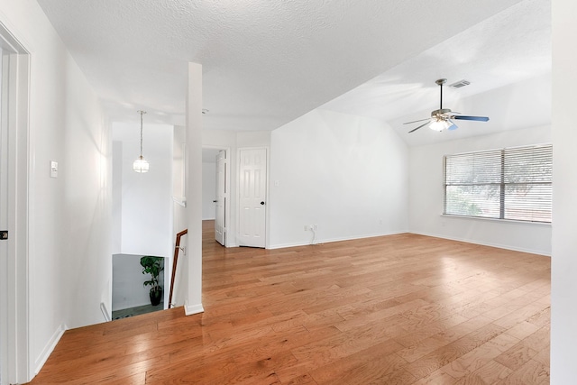 23010 Adwick Ct, Katy, TX 77450 - empty room featuring light wood-style floors, ceiling fan, a textured ceiling, and vaulted ceiling