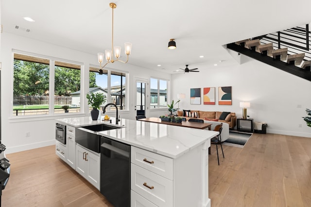 946 Euel Moore Dr, Kingsland, TX 78639 - kitchen with black dishwasher, light wood-type flooring, white cabinetry, a center island with sink, and recessed lighting