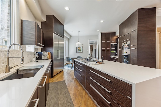 3926 Oberlin St, West University Place, TX 77005 - kitchen with modern cabinets, appliances with stainless steel finishes, decorative backsplash, light wood finished floors, and recessed lighting