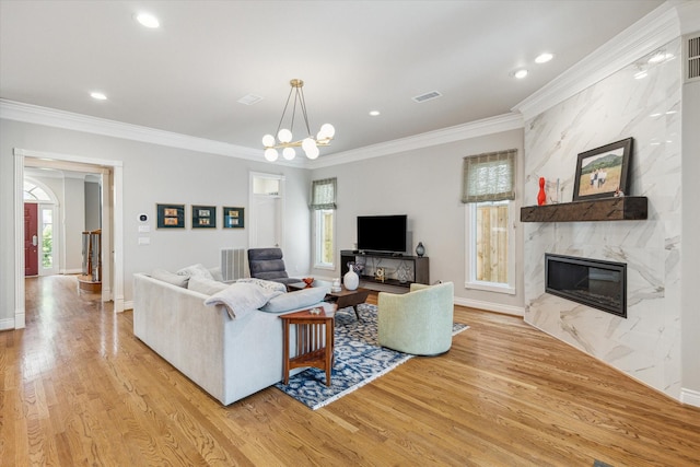 3926 Oberlin St, West University Place, TX 77005 - living room featuring light wood-style floors, ornamental molding, a premium fireplace, a chandelier, and recessed lighting