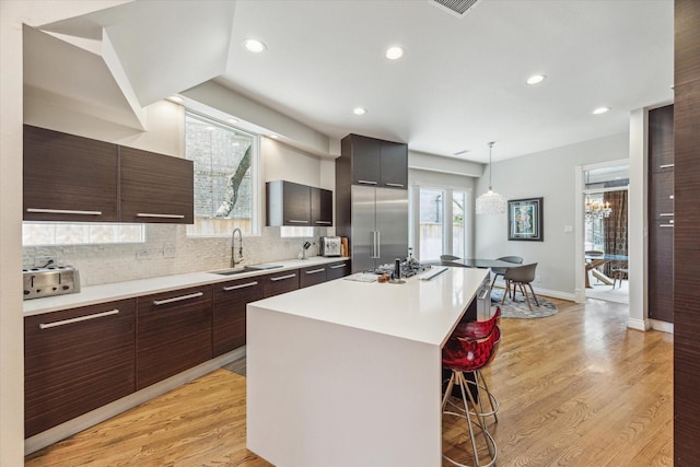 3926 Oberlin St, West University Place, TX 77005 - kitchen featuring appliances with stainless steel finishes, a kitchen breakfast bar, light countertops, a center island, and modern cabinets