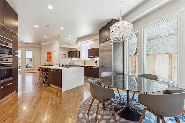 3926 Oberlin St, West University Place, TX 77005 - dining space with plenty of natural light, light wood-style floors, recessed lighting, crown molding, and a chandelier