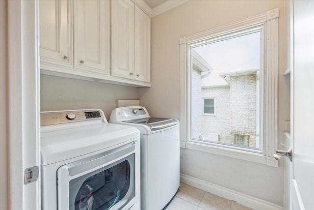 3926 Oberlin St, West University Place, TX 77005 - laundry room featuring washing machine and dryer, cabinet space, light tile patterned flooring, and plenty of natural light